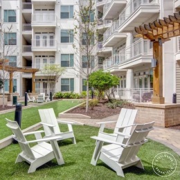 a courtyard with chairs on grass